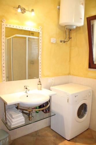 a bathroom with a sink and a washing machine at New Orange Studio 9 in Budoni