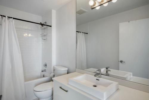 a white bathroom with a sink and a toilet at High Floor Pool Gym Brickell in Miami