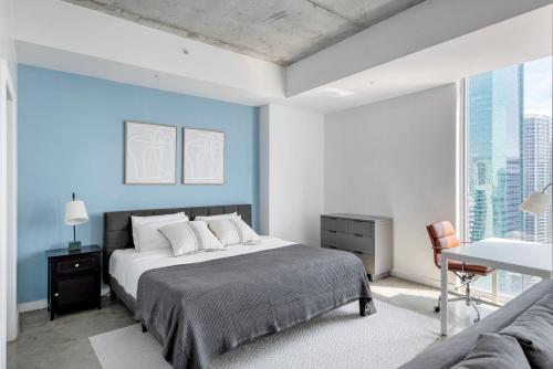a bedroom with a bed and a blue wall at High Floor Pool Gym Brickell in Miami