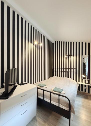 a bedroom with a black and white striped wall at Alandala by The Center in Cluj-Napoca