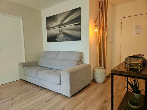 a living room with a couch and a table at Le splend'id à 10min de Disneyland in Chessy