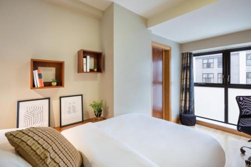 a bedroom with a large white bed and a window at Canvas Cúirt na Coiribe Galway in Galway
