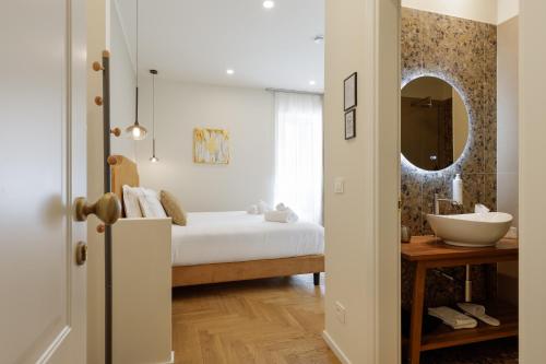 a bedroom with a bed with a sink and a mirror at Neris Boutique Rooms in Muggia