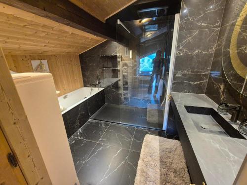 a bathroom with a sink and a bath tub at Hôtel Le Labrador 1971 in Les Gets