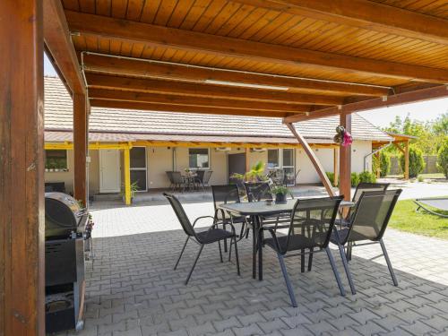 a patio with a table and chairs under a wooden roof at Apartment Lena 2 by Interhome in Balatonberény