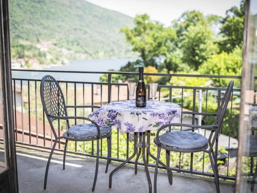 a table and two chairs with a bottle on a balcony at Holiday Home Iside by Interhome in Mergozzo