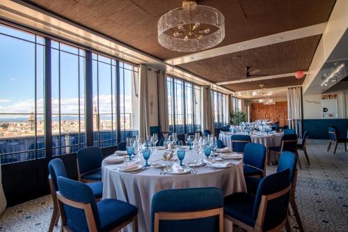 a room with tables and chairs and large windows at Only YOU Hotel Valencia in Valencia