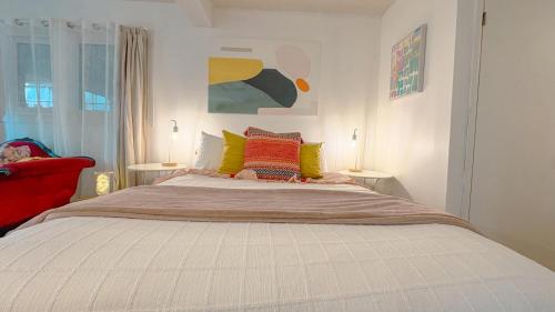 a bedroom with a large white bed with colorful pillows at KingstonStays The Art Studio free parking in Kingston