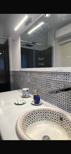 a bathroom with a tub with two plates and a mirror at Blue Tao Maison Taormina in Taormina