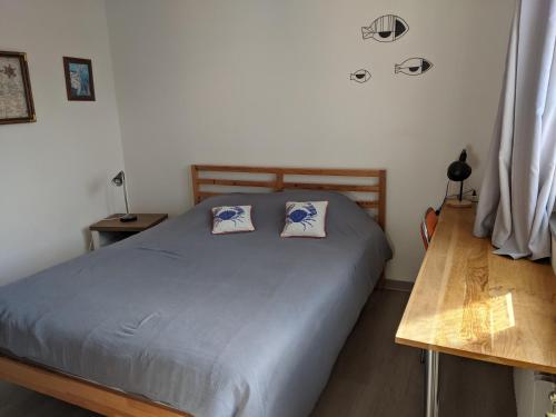 a bedroom with a bed with two pillows on it at Mousse appart 3 pers à Sangatte au 1e étage à 50 metres de la plage in Sangatte