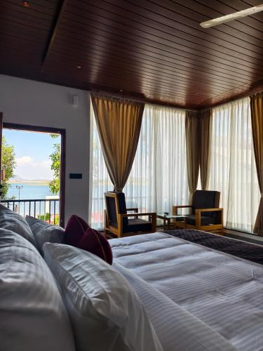 a bedroom with a large bed with a view of the ocean at Coorg Tiger Eye Backwater Resort in Kushālnagar