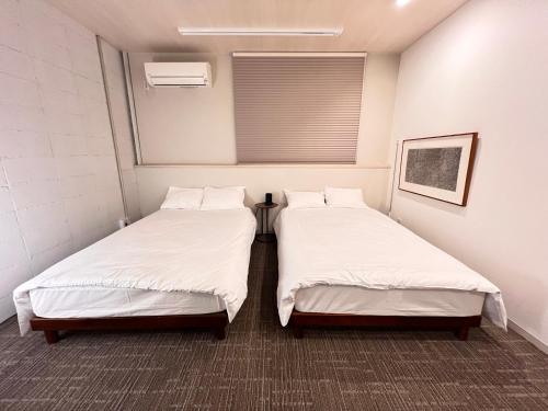 two beds sitting next to each other in a room at 内町2階 1フロアまるごと貸切 高松中心部 4名まで in Takamatsu
