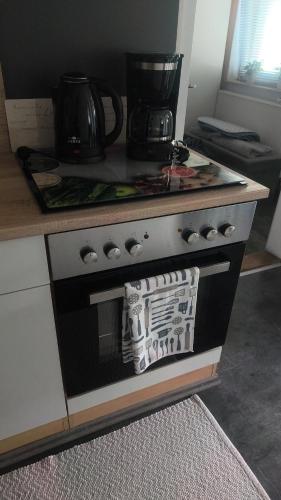a stove top oven with a microwave on top of it at FeWo Mephisto in Pottenstein