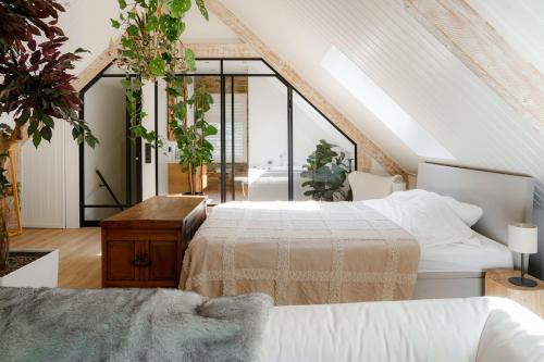 a attic bedroom with two beds and plants at Villa De Musschenberg in Beek
