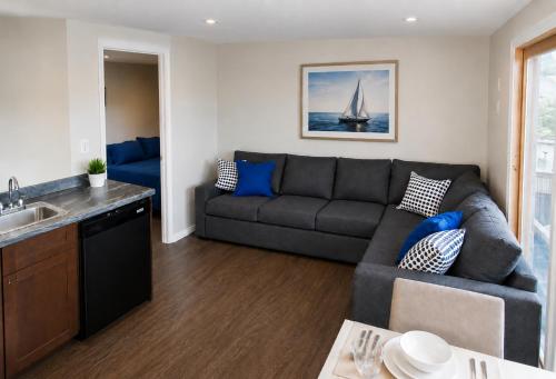 a living room with a gray couch and a kitchen at 58 River Rd. East in Wasaga Beach