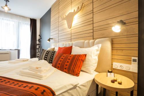 a bedroom with a bed with pillows and a table at Complex Vazrozhdentsi in Tryavna