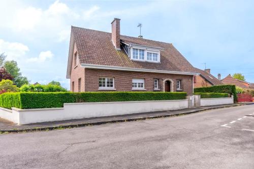 a red brick house with a roof at L'Escale - Maison 5CH & Jardin in Bray-Dunes
