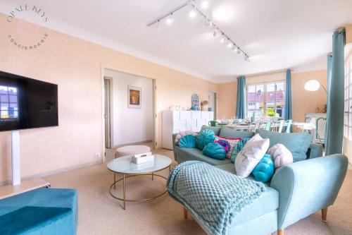 a living room with a couch and a table at L'Escale - Maison 5CH & Jardin in Bray-Dunes