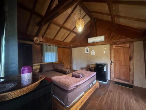a bedroom with a bed and a couch in a room at Cozy cove hut in Pulau Sarang