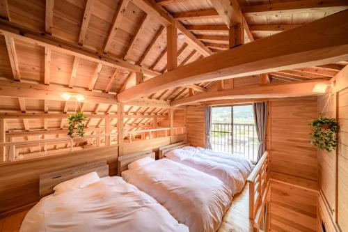 a bedroom with two beds in a wooden room at 結の里 in Gero