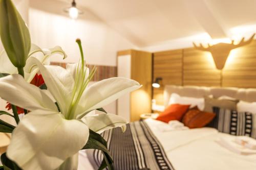 a hotel room with a bed and a white flower at Complex Vazrozhdentsi in Tryavna