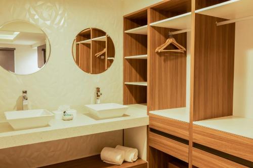 a bathroom with two sinks and a mirror at Gamma Ciudad Juarez in Ciudad Juárez