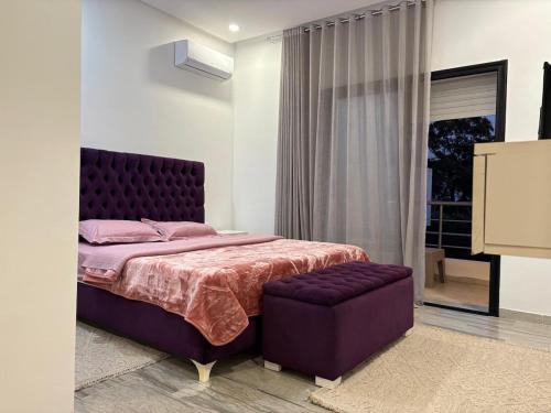 a bedroom with a large bed with a purple headboard at Dar Selima Hammamet in Hammamet