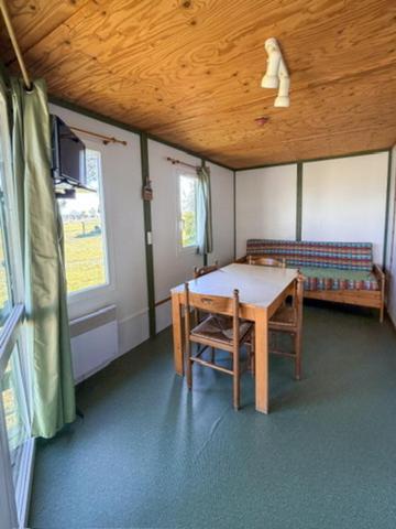 a room with a table and a bench in a room at Ferme de L'Aoueille in Pouylebon