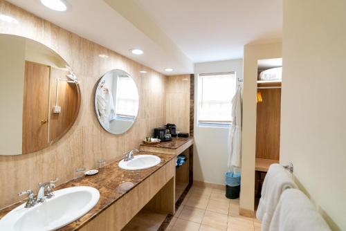a bathroom with two sinks and a mirror at Fourways Inn in Chelston