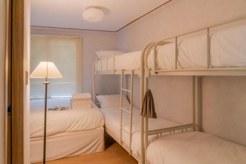 a bedroom with two bunk beds and a lamp at 메종드브릭 호텔 in Seoul