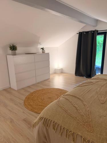 a bedroom with a bed and a dresser and a window at L apparte Sciez in Sciez