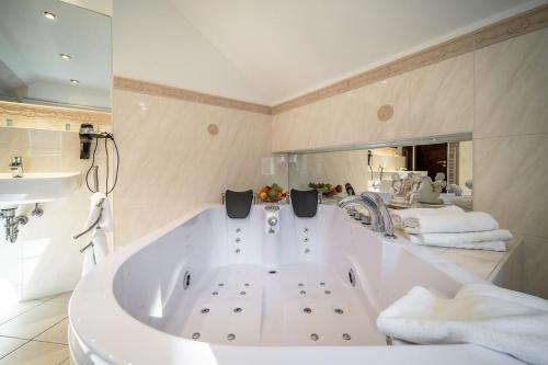 a large white bath tub in a bathroom with towels at Villa Rosenburg in Thale