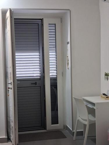 a room with a door with a window and a table at Amoenus Bed & Breakfast in family in Soverato Marina