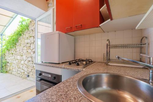 a kitchen with a sink and a stove at Le Mas Boyer in Chauzon