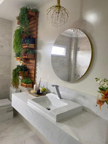 a bathroom with a white sink and a mirror at Hotel Tauari in Marabá