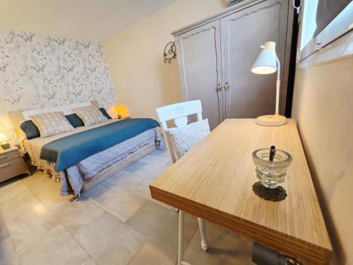ein Schlafzimmer mit einem Bett und einem Tisch mit einer Lampe in der Unterkunft Poly's House in Tomares