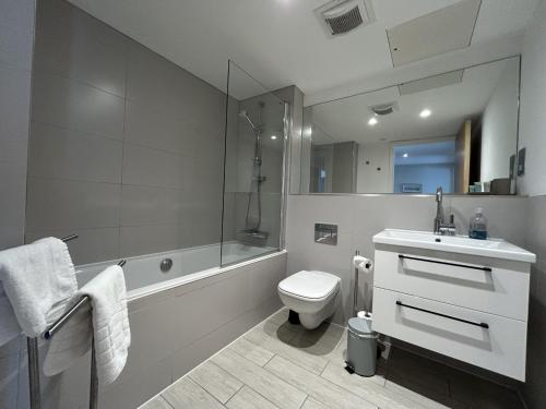 a bathroom with a sink and a toilet and a tub at Tolbooth Apartments by Principal Apartments in Glasgow