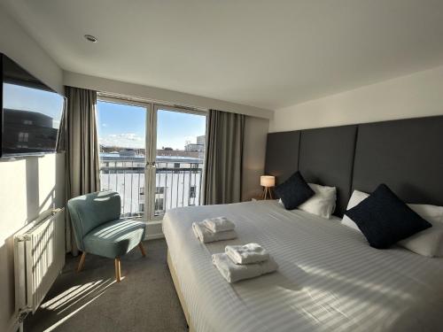 a bedroom with a bed with a chair and a window at Tolbooth Apartments by Principal Apartments in Glasgow