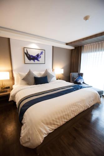 a large bed in a hotel room with two lamps at Arte Hotel - SHA Extra Plus in Bangkok