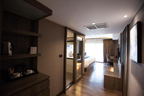 a hotel room with a bed and a bathroom at Arte Hotel - SHA Extra Plus in Bangkok