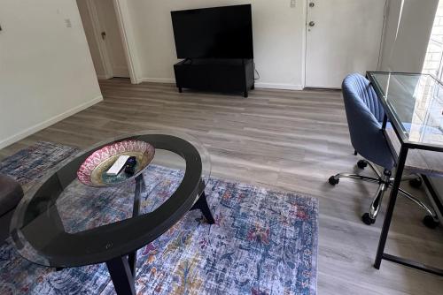 a living room with a glass table and a chair at Location Lake Eola View 1 Bedroom condo in Orlando