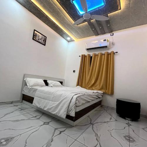 a bedroom with a bed and a ceiling with a blue light at Hotel White Palace in Nāwa