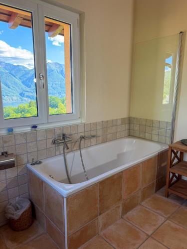 a bath tub in a bathroom with two windows at Casa Kasia by HolAp SA in Contra