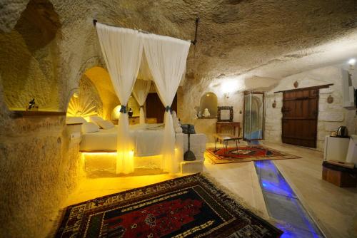 a bedroom with a bed with curtains in a cave at Cappadocia Nar Cave House & Swimming Pool in Nevşehir