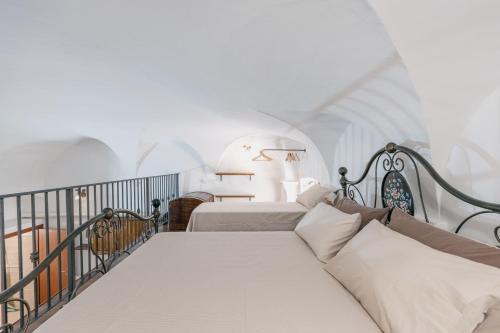 a bedroom with two beds and a balcony at BHR - Il Nido di Trevi in Trevi