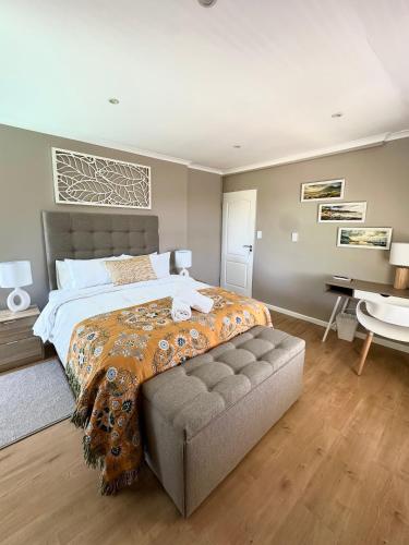 a bedroom with a large bed and a desk at Wellway Place in Durbanville