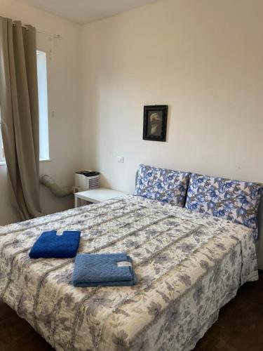 a bedroom with a bed with two blue towels on it at Rachana Guest House in Mestre