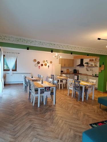 a dining room with tables and chairs and a kitchen at Casa Măriucăi - Ciubar&Mountain View in Borşa