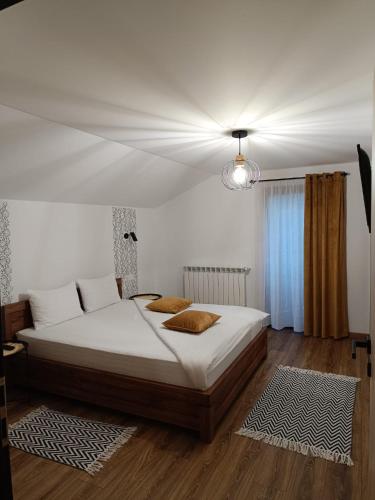a bedroom with a large bed with white sheets at Casa Măriucăi - Ciubar&Mountain View in Borşa
