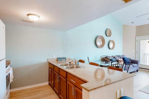 a kitchen with a sink and a living room at Gulf Point Condominiums in South Padre Island